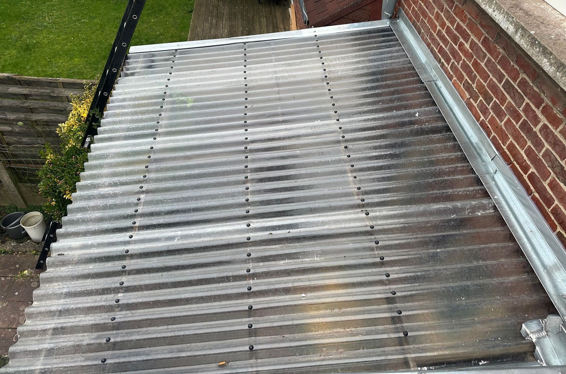 Toit plat recouvert de goudron noir et bordé de métal.