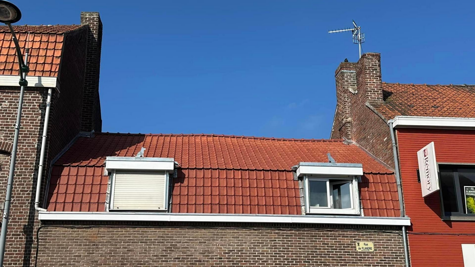 Bâtiments en briques aux toits de tuiles orange.