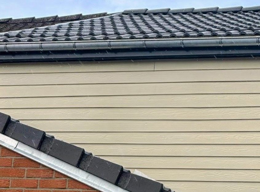 Un bardage en bois gris foncé.