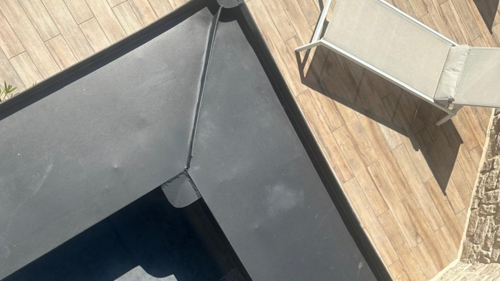 Toiture en ardoise avec des tuiles déplacées et cassées.