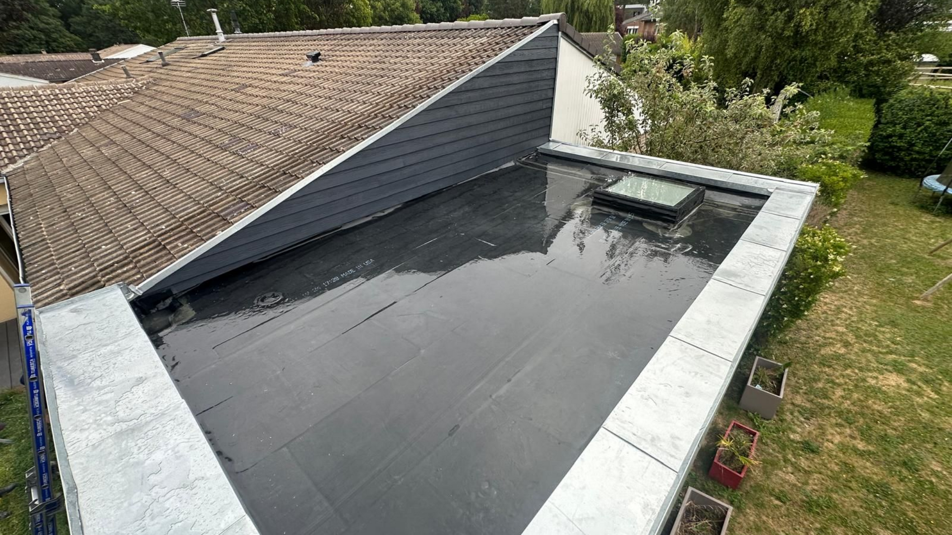 Toit plat et noir avec des puits de lumière.