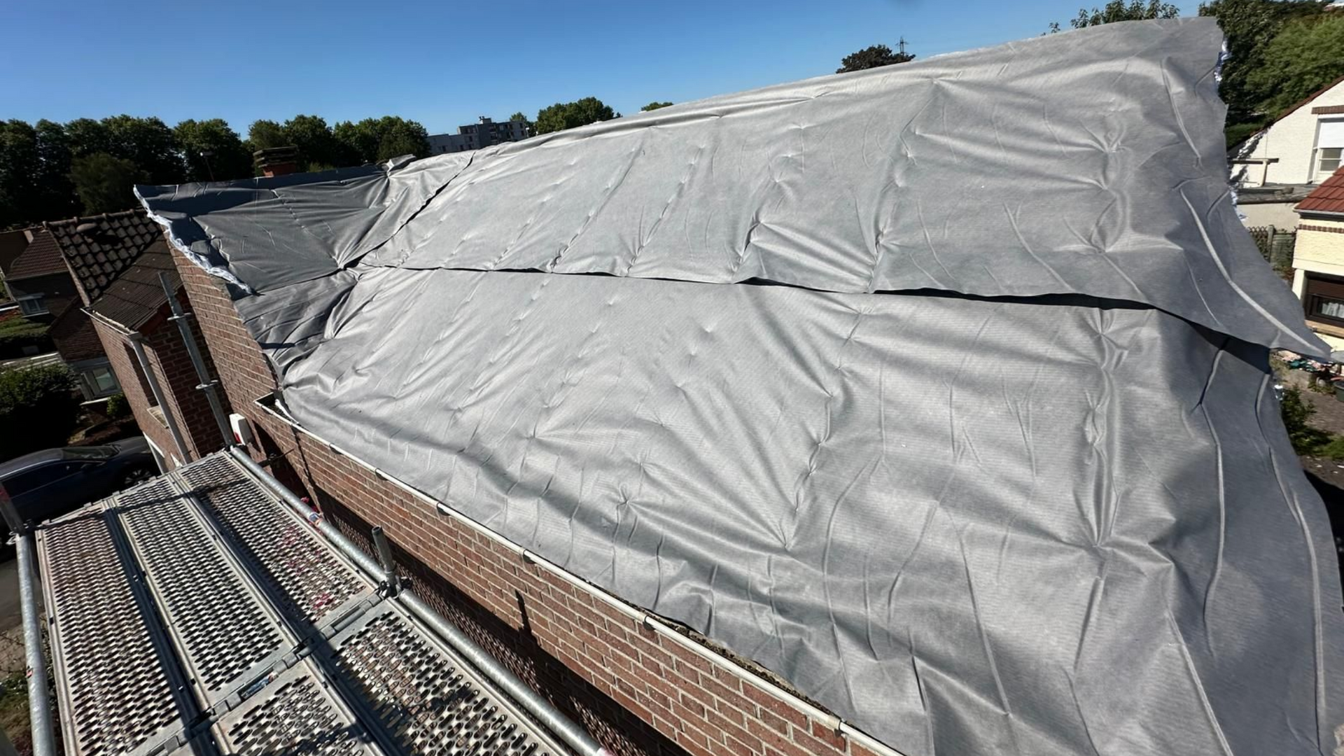 Des échafaudages soutiennent un toit en construction.