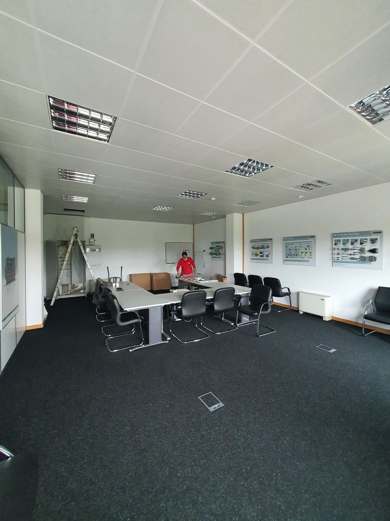 Um homem de camisa vermelha dentro de um escritório remodelado