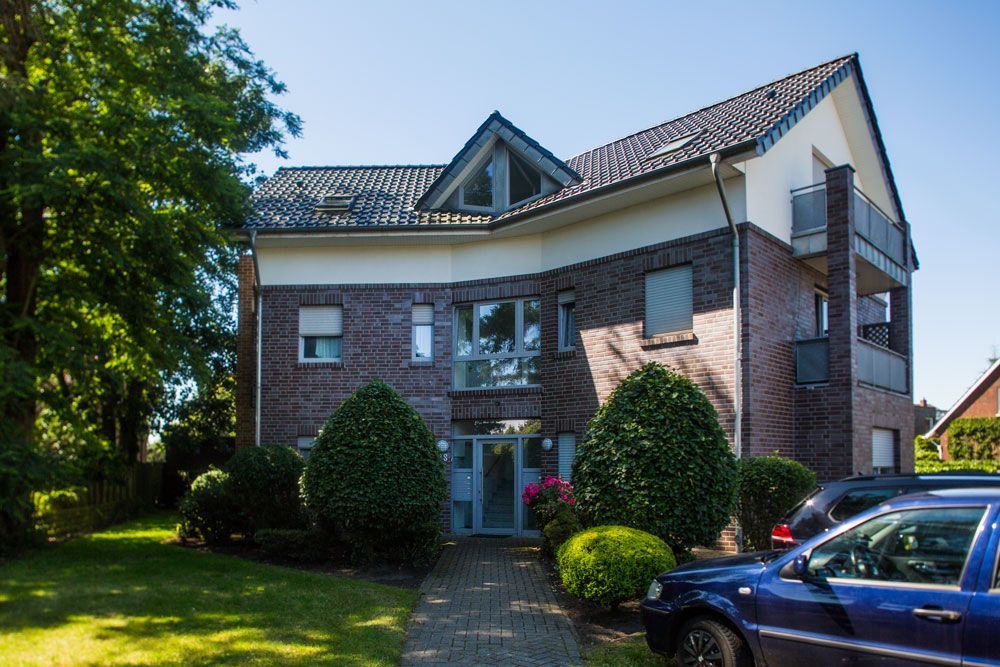 Ein großes Backsteingebäude mit davor geparkten Autos