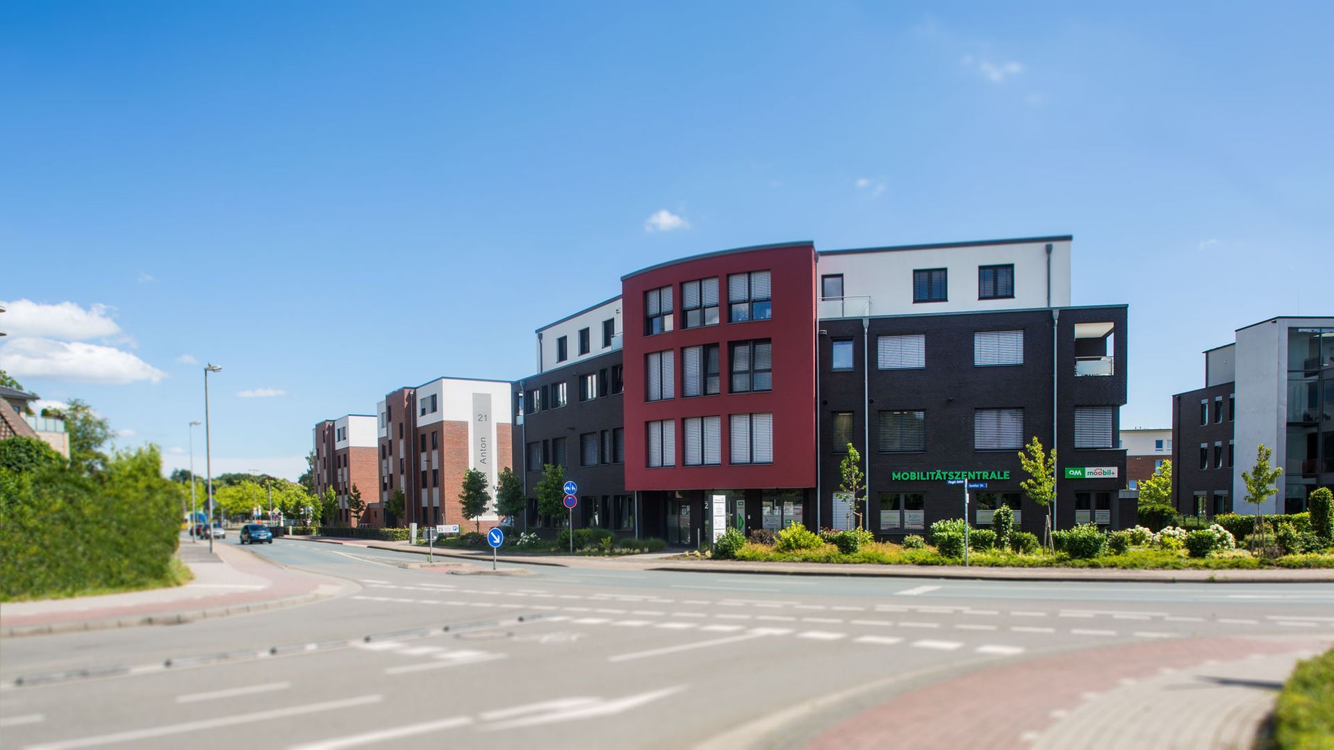 An einer Straßenecke steht ein rot-weißes Gebäude.