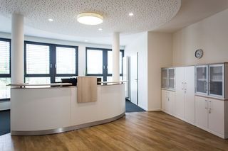 In der Mitte des Zimmers hängt eine Uhr an der Wand.