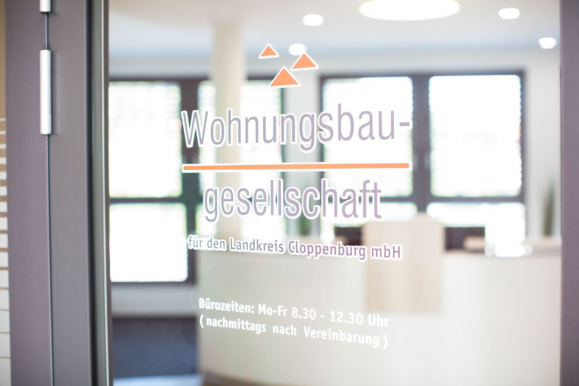 Eine Glastür mit einem Schild darauf, auf dem steht: Wohnungsbaugesellschaft