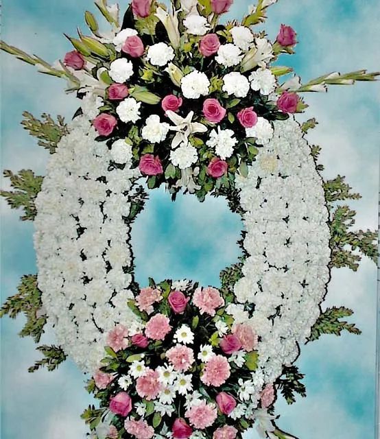 Una corona de flores blancas y rosas sobre un fondo azul.