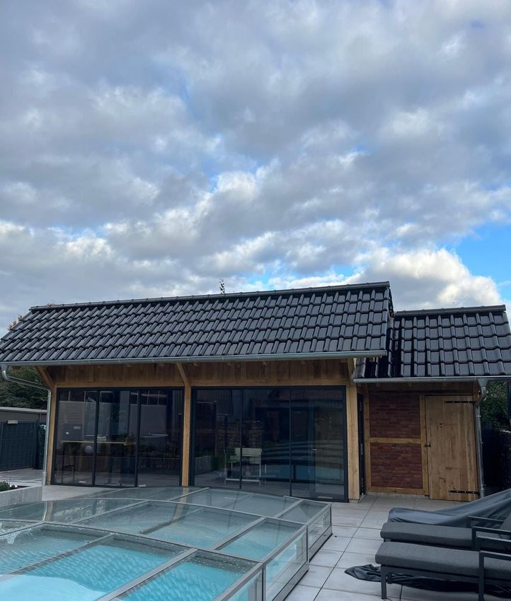 Drei Personen stehen vor einem Haus.