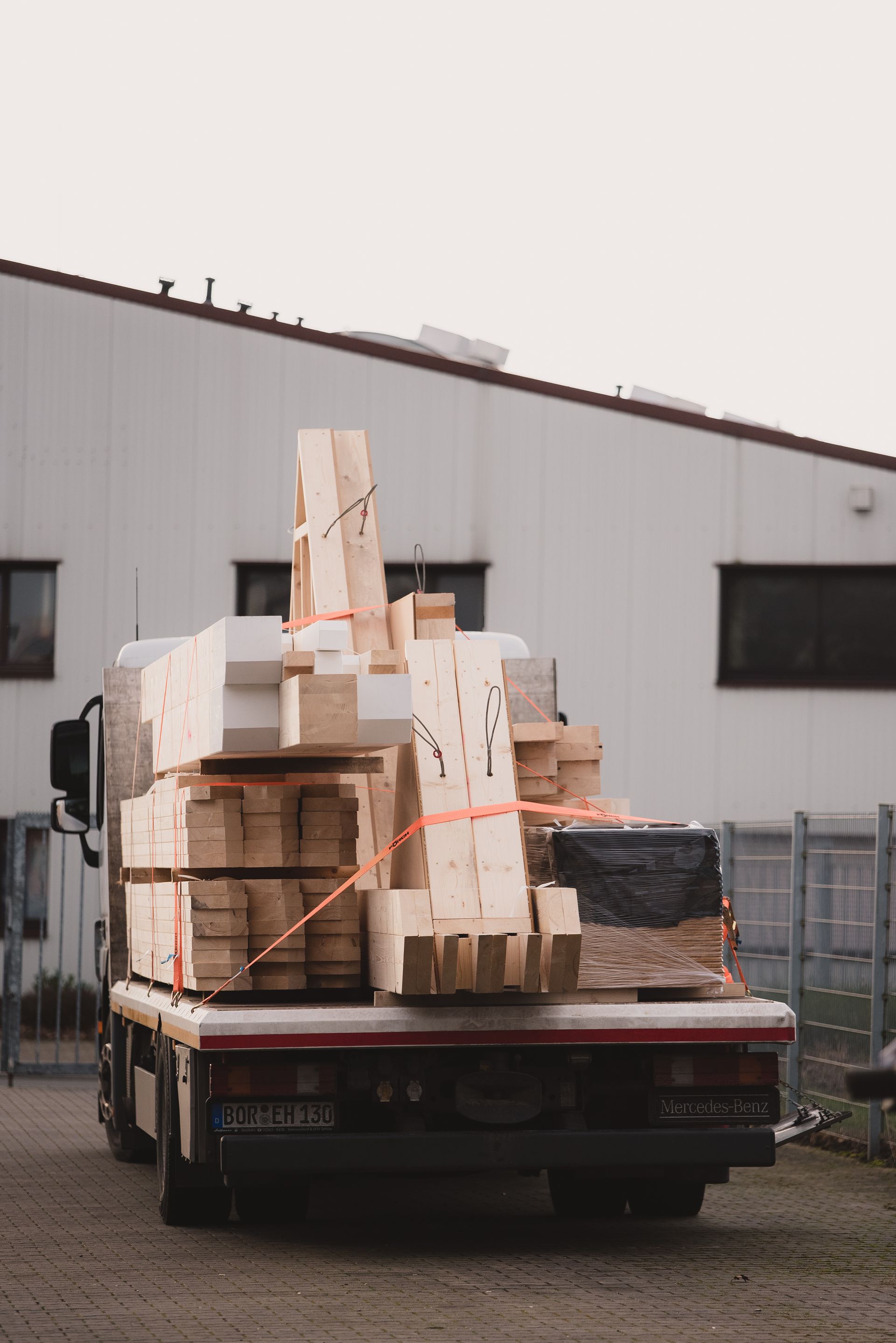 Ein Lastwagen transportiert einen großen Stapel Holz.
