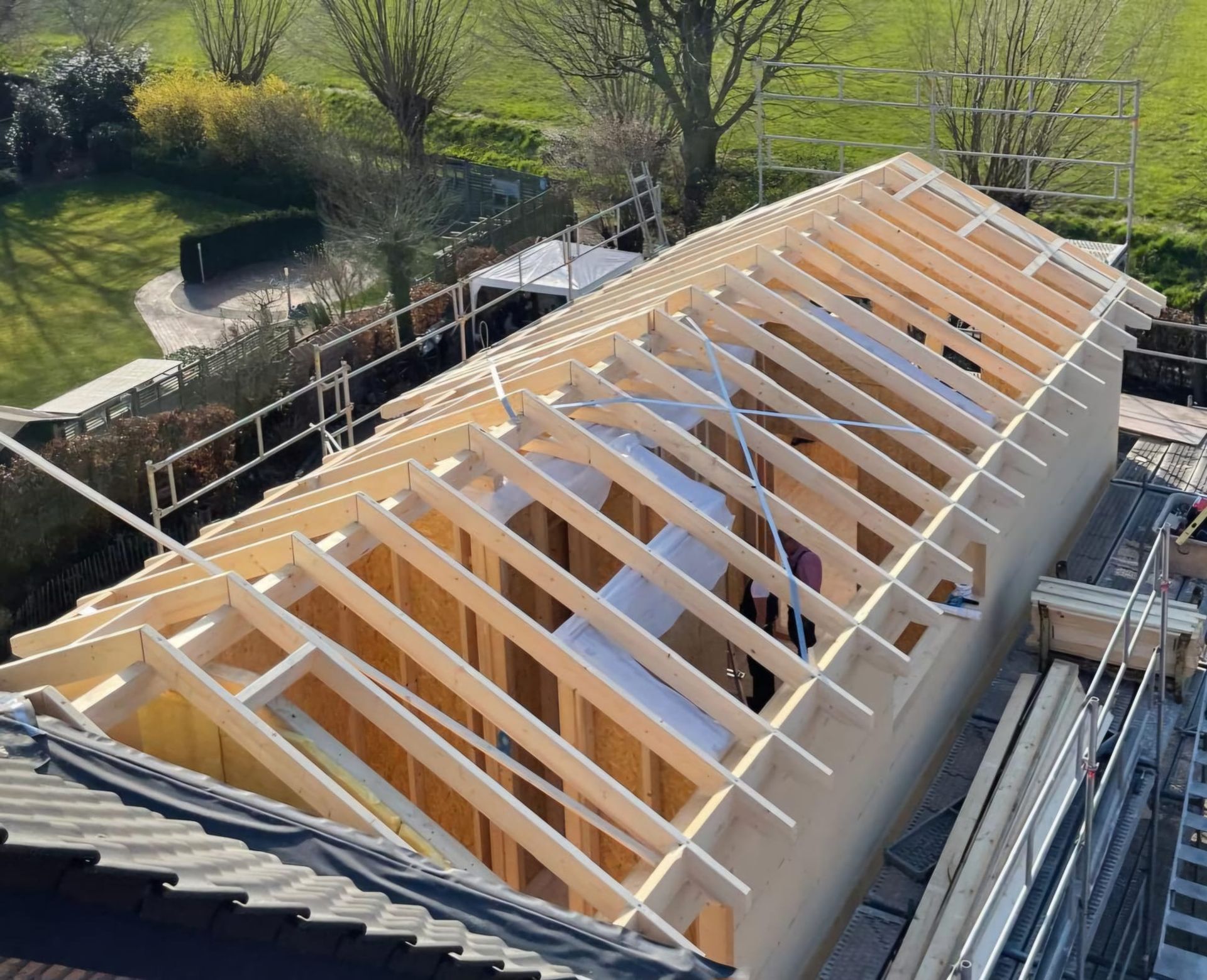 Das Dach eines Hauses wird mit Holzbalken gebaut.