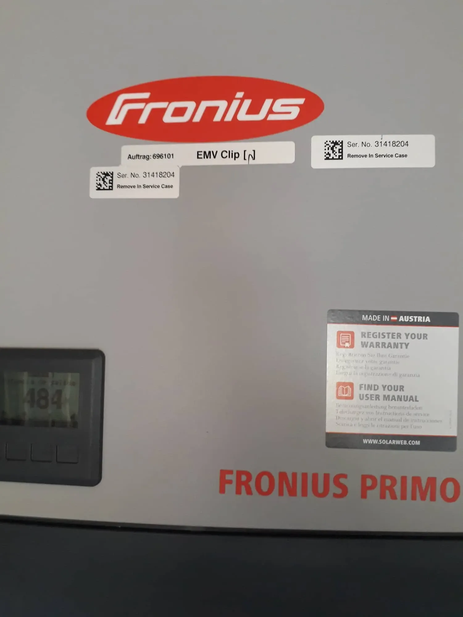 Primer plano de un inversor solar Fronius Primo con pantalla y etiquetas en un panel gris.