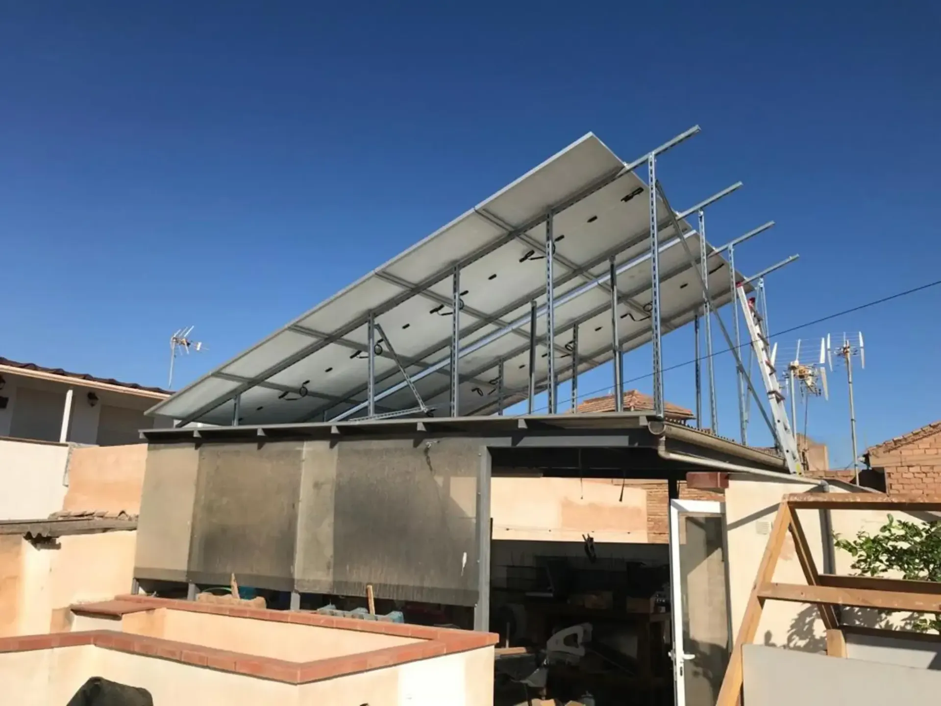 Gran conjunto de paneles solares instalados en un tejado bajo un cielo azul despejado.