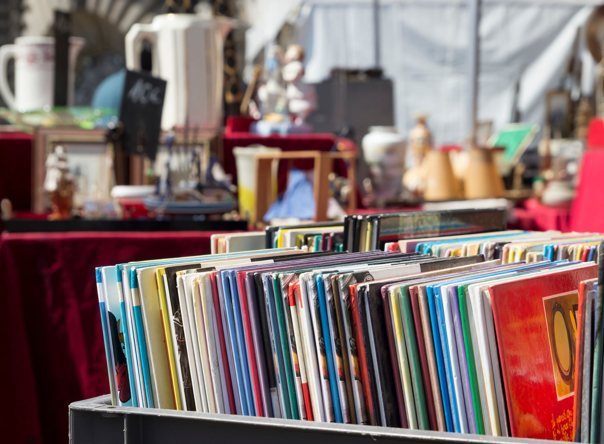 Des rangées de disques vinyles colorés sur un étal de marché en plein air