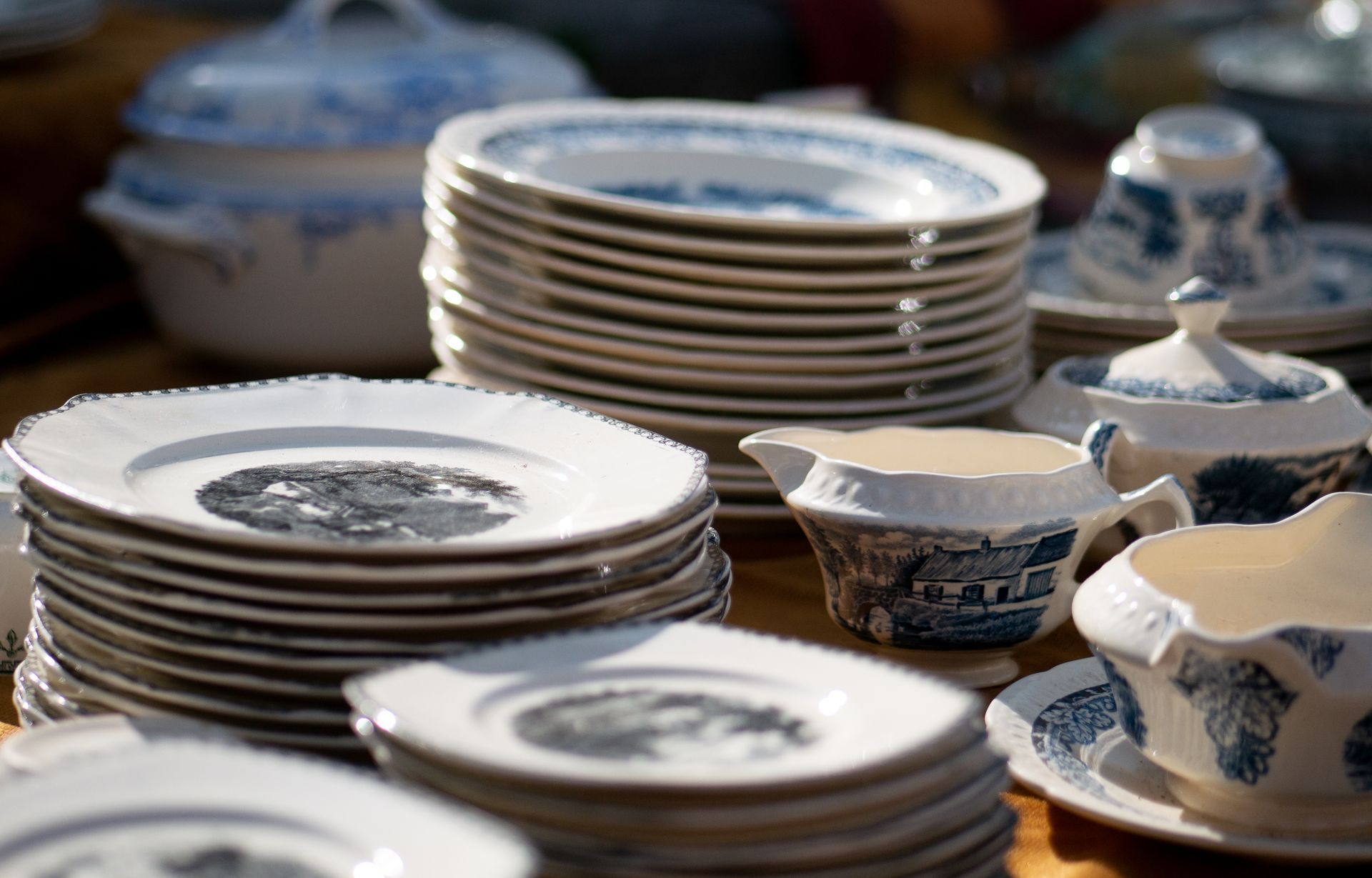 Des piles d'assiettes et de tasses à thé en porcelaine bleue et blanche sur une table