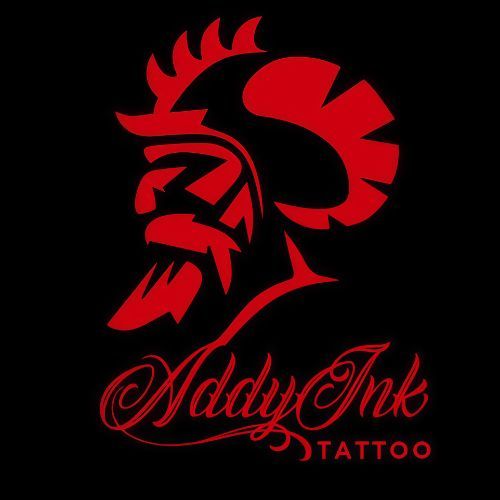 Un gr&aacute;fico rojo estilizado de una cabeza de gallo combinada con un casco de guerrero, sobre el texto "Addy Ink TATTOO"