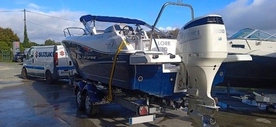 Bateau bleu sur remorque avec un moteur hors-bord
