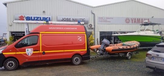 Un fourgon de secours orange remorque des bateaux