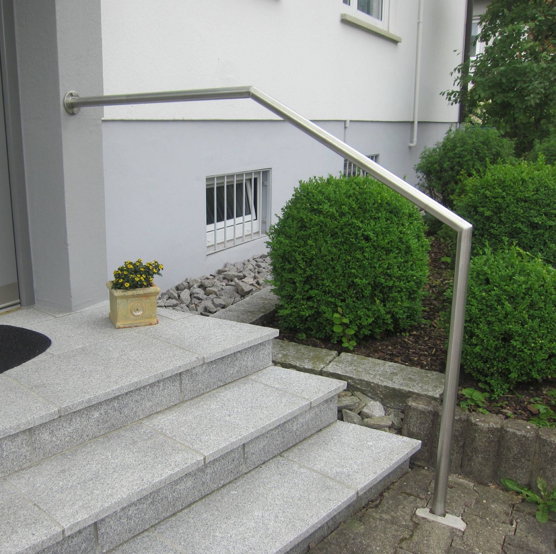 ein Blumentopf steht auf einer Treppe vor einem Haus