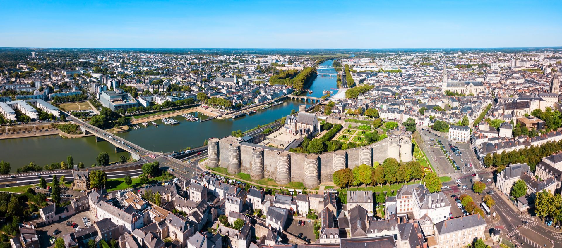 Vue aérienne du château d'Angers, en France, avec ses remparts de pierre surplombant le Maine et les bâtiments de la ville environnante.