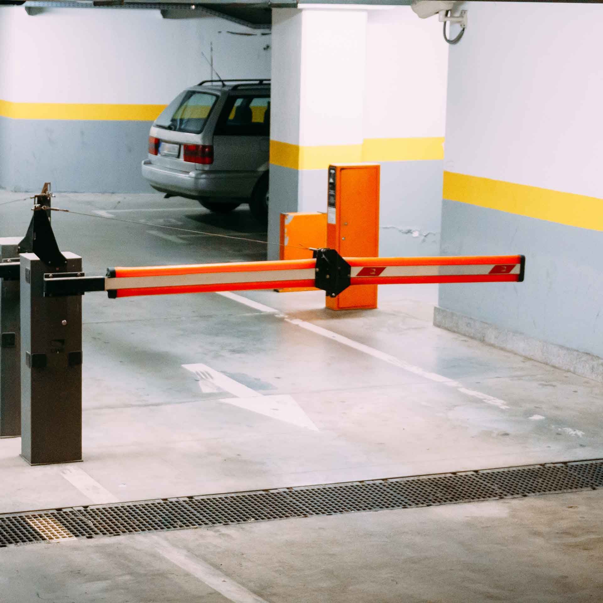 Barrière de stationnement avec bras rouge et voiture garée en arrière-plan
