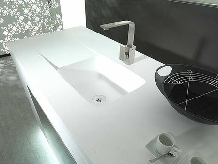 Lavabo moderno blanco con grifo cromado y cubeta negra sobre encimera.