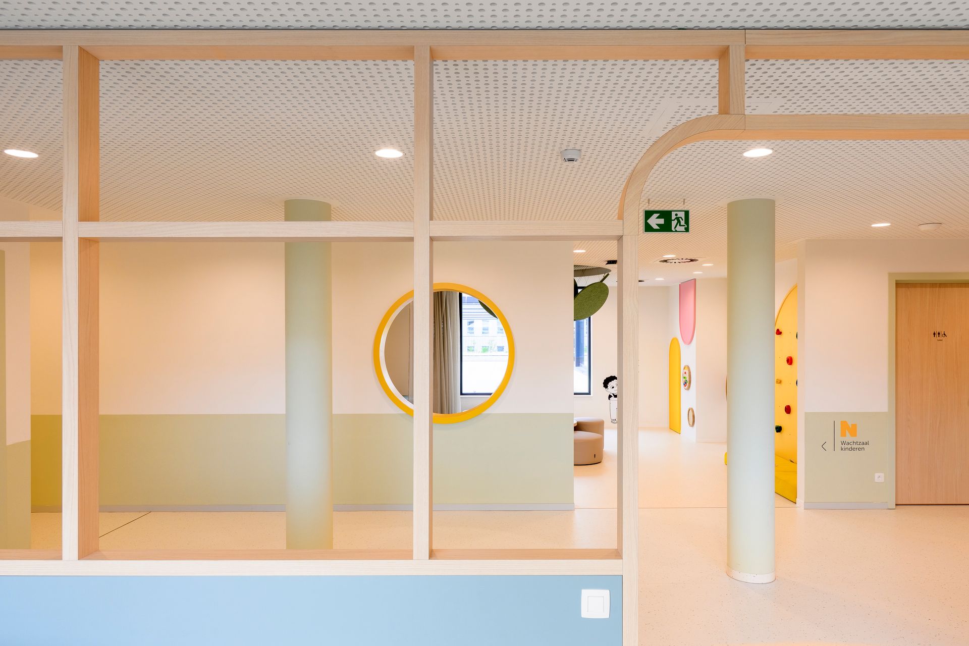 Lichte, moderne hal met glazen scheidingswanden, witte muren en een ronde raamopening