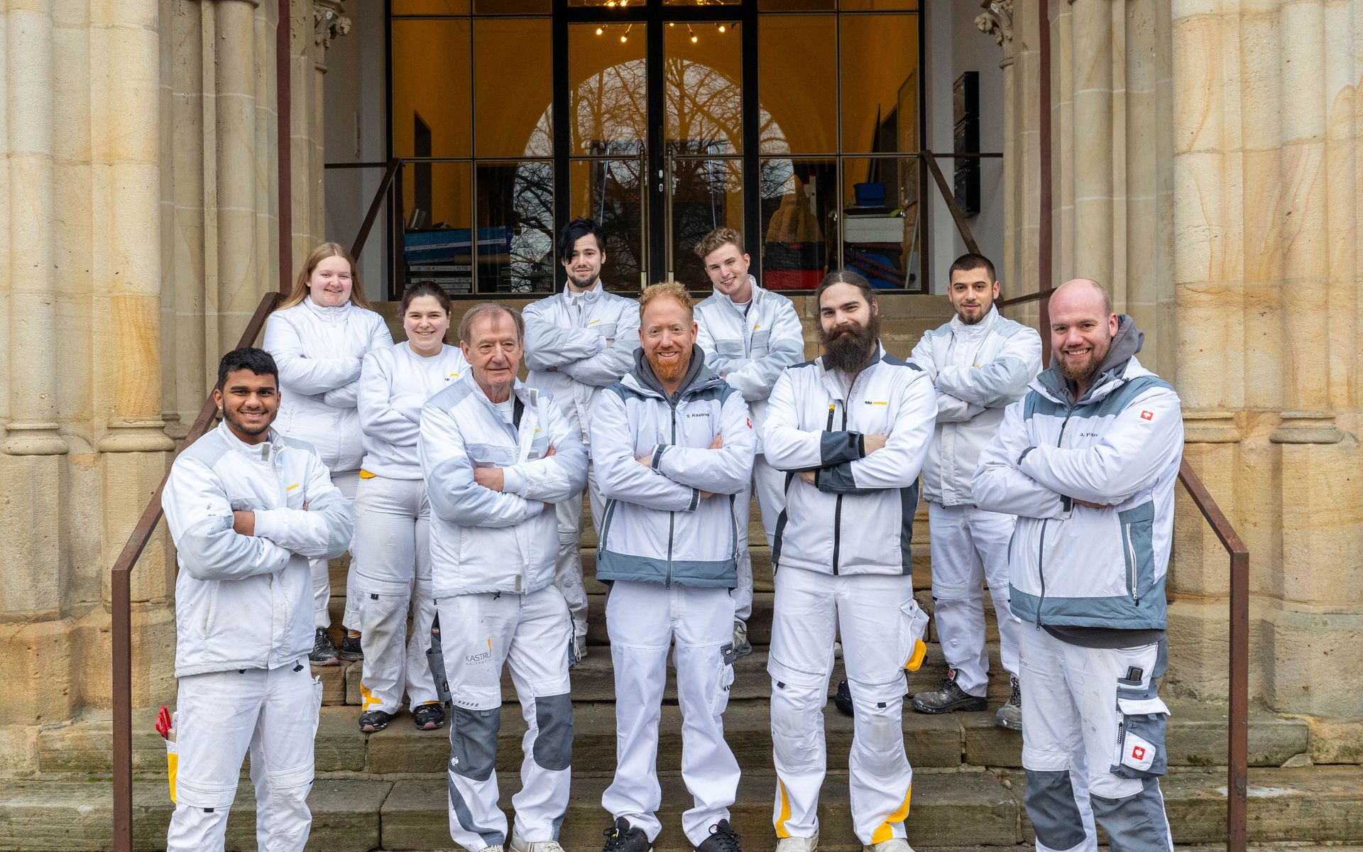 Eine Gruppe von Menschen posiert vor einem Gebäude für ein Foto.