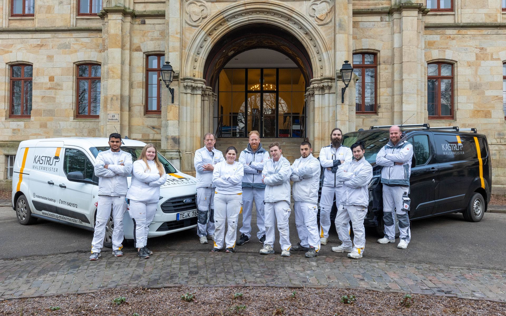 Eine Gruppe von Menschen posiert vor einem Gebäude für ein Foto.