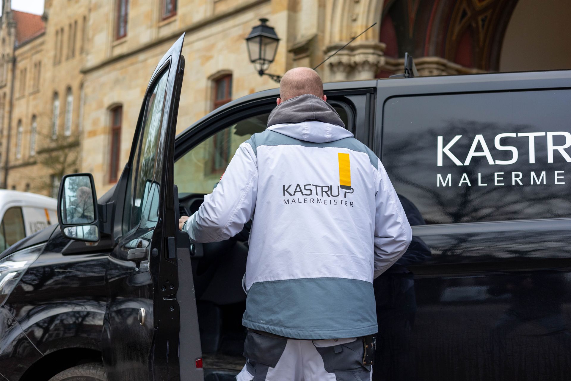 Ein Mann steigt aus einem schwarzen Lieferwagen.