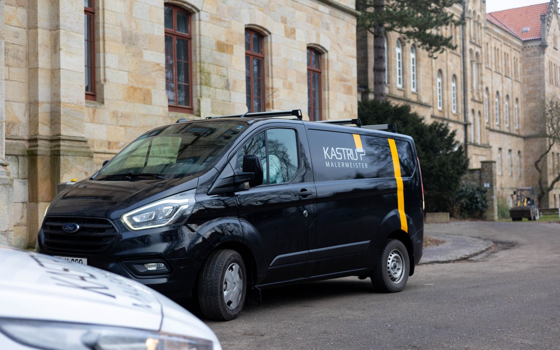 Ein schwarzer Lieferwagen steht vor einem Gebäude.