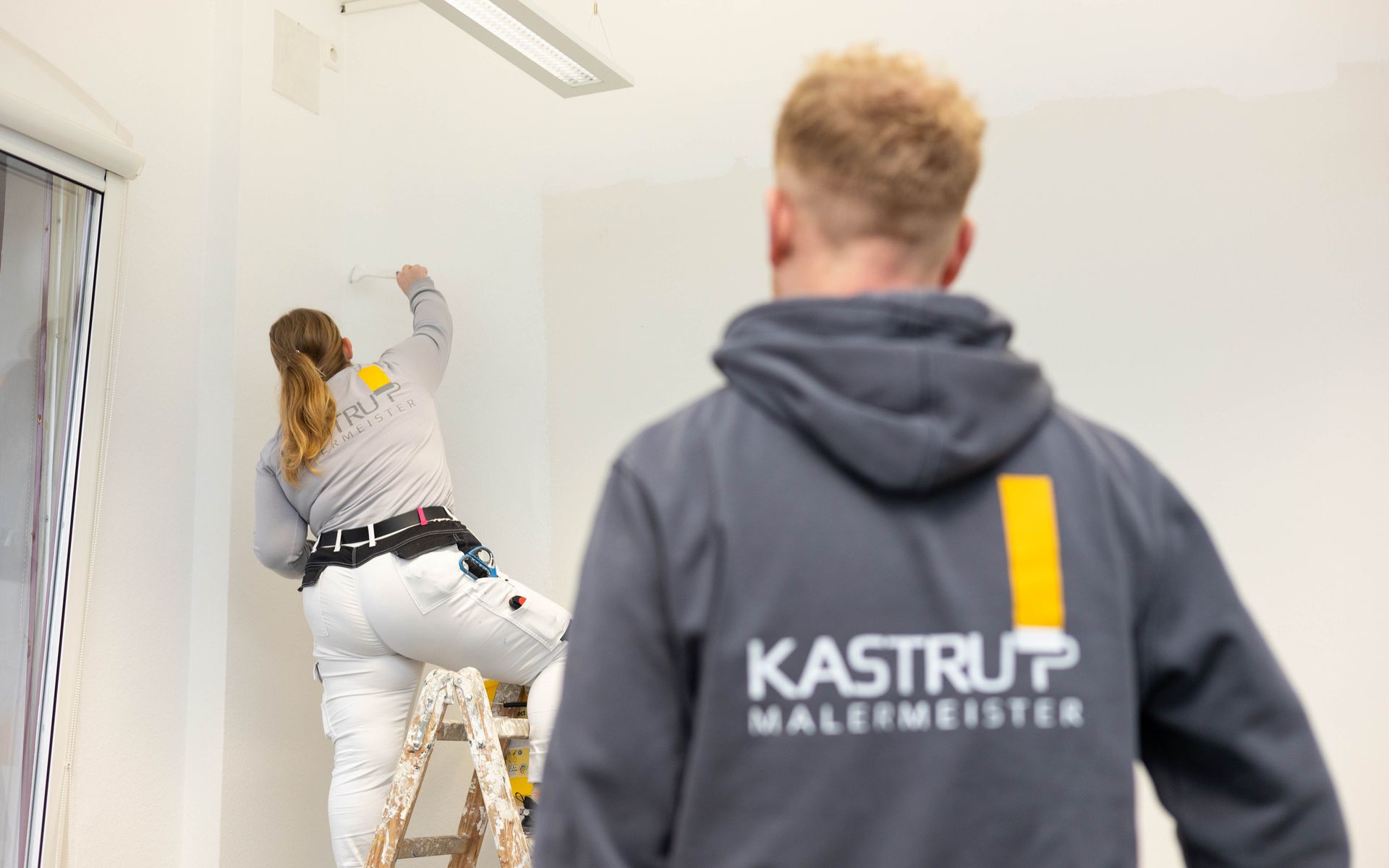 Ein Mann und eine Frau streichen eine Wand.