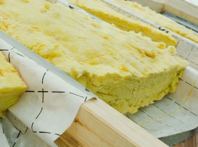 Un primer plano de un trozo de aislamiento amarillo en una caja de madera.