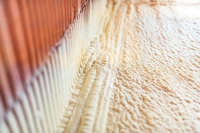 Un primer plano de un aislamiento de espuma que se aplica a una pared.