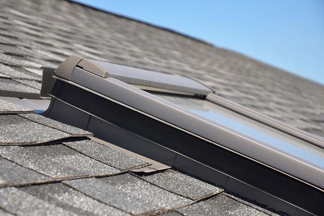 Un tragaluz en un tejado con un cielo azul de fondo