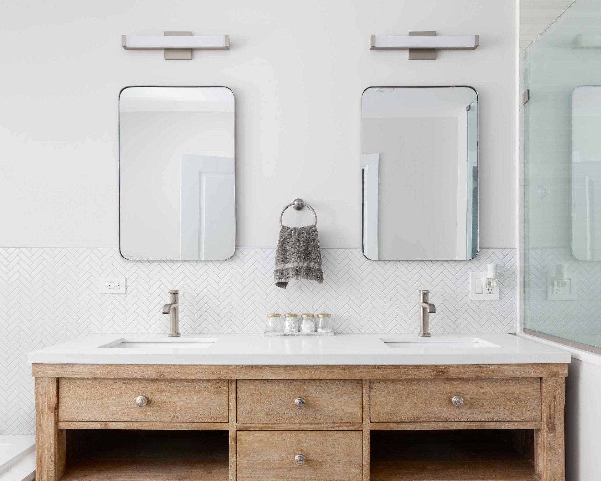 Un baño con dos lavabos y dos espejos