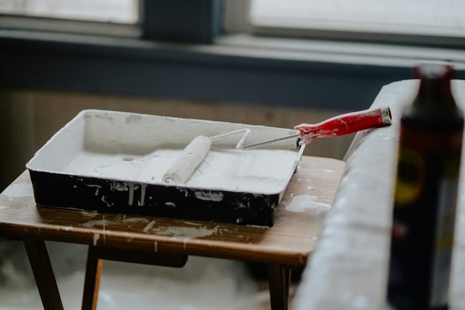 Un rodillo de pintura está colocado encima de una mesa de madera.