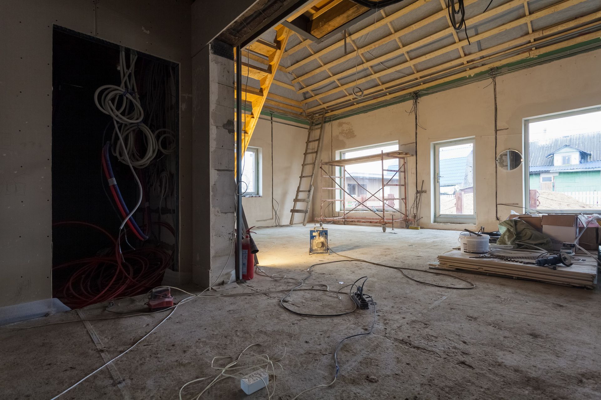 Una habitación en construcción con muchos cables en el suelo.
