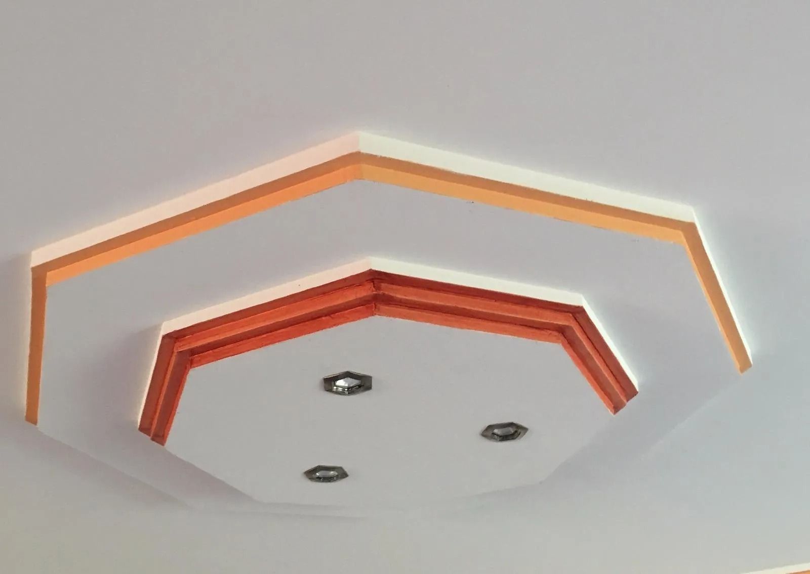 Plafond octogonal encastré avec éclairage d'accentuation orange et trois spots encastrés