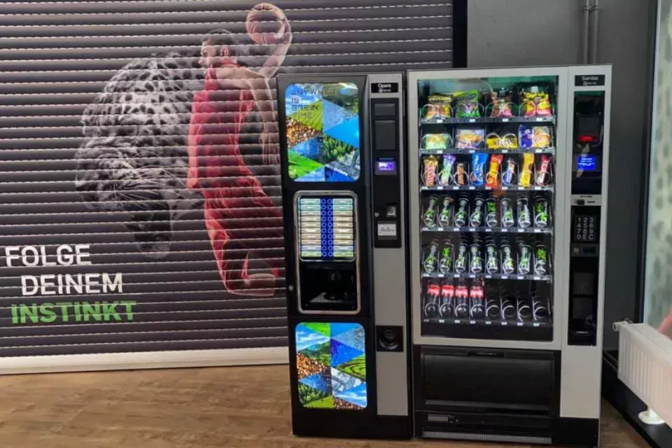 Vending machine beside a shuttered storefront with “FOLGE DEINEM INSTINKT” on the wall.