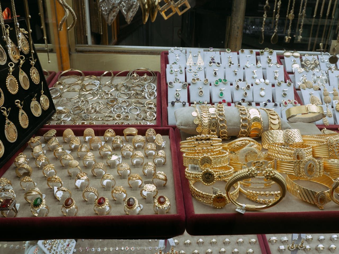 Una exhibición de joyas de oro que incluye anillos y pulseras.