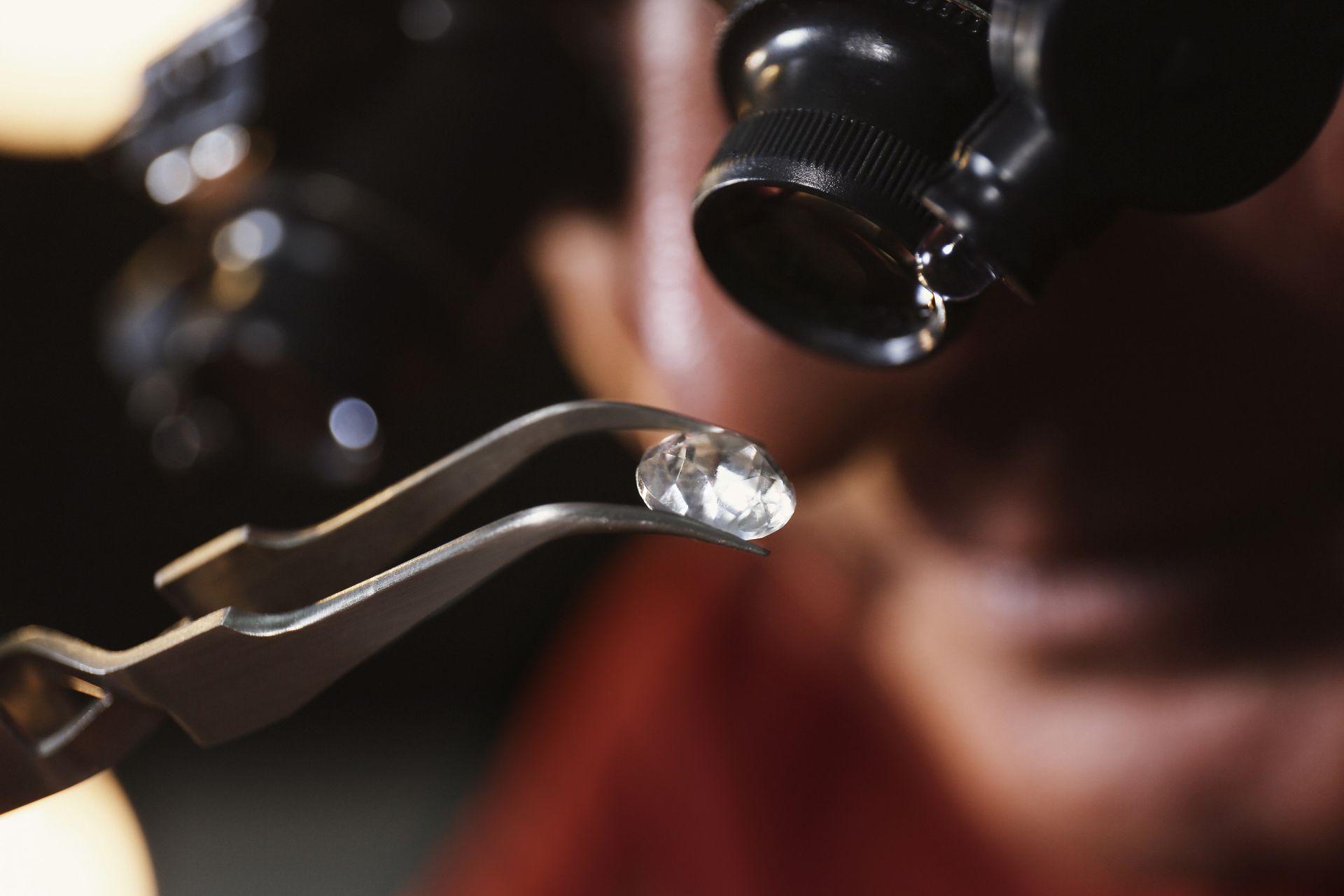 Una persona está mirando un diamante bajo una lupa.