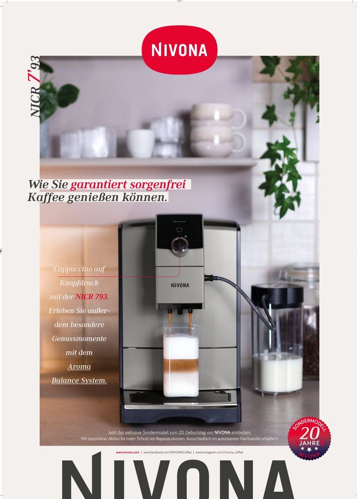 Eine Nivona-Kaffeemaschine mit einem Latte auf der Küchentheke, Regale und Tassen im Hintergrund.