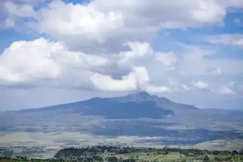 A view of a mountain with clouds in the sky.