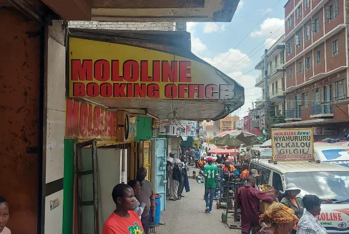 A group of people are walking down a busy street in front of a building.