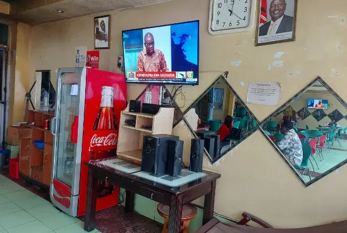 A room with a coca cola fridge and a flat screen tv