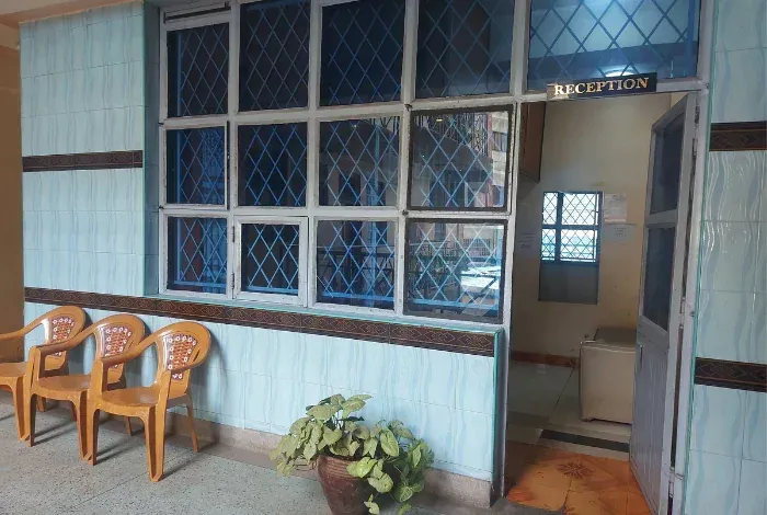 A room with chairs and a plant in front of a window that says reception.