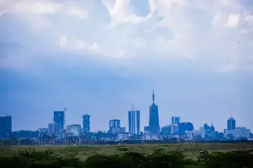 A city skyline with a blue sky and clouds in the background