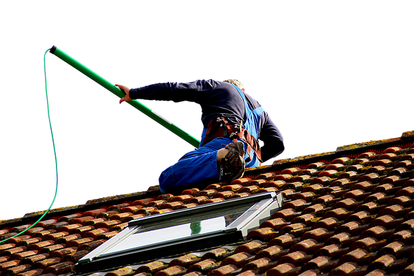 Un homme sur une toiture pour du nettoyage