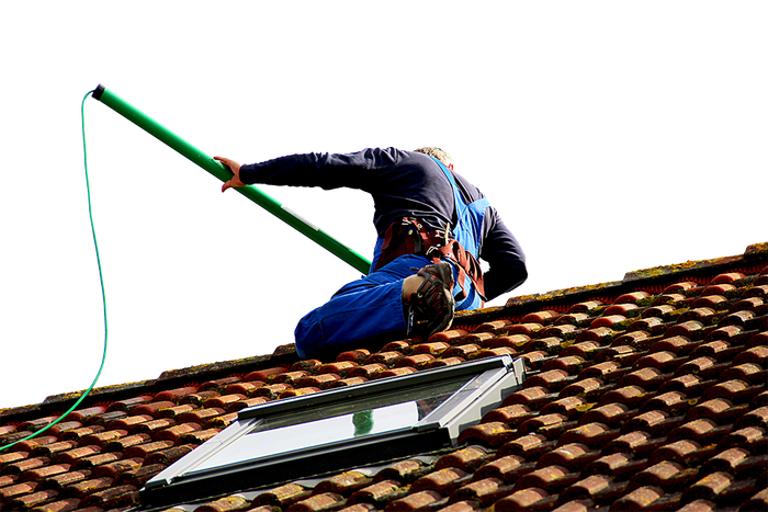 Un homme sur une toiture pour du nettoyage